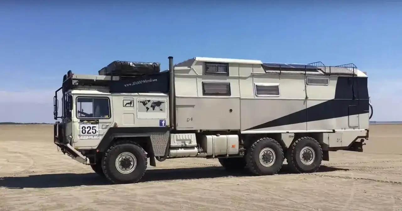 Potężne kampery terenowe na piaszczystym podłożu, gotowe na przygodę.