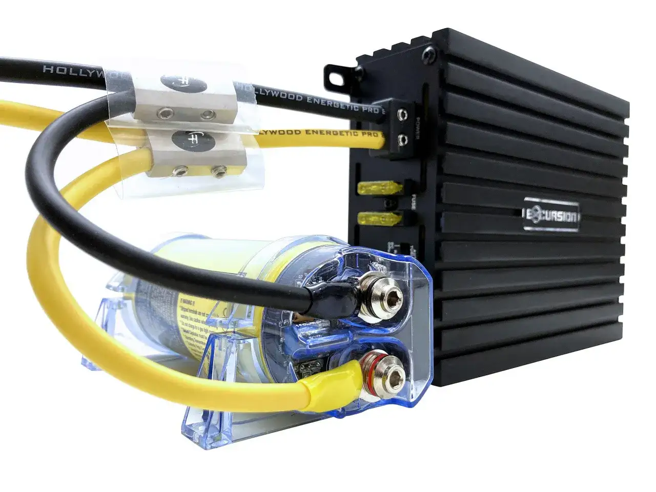 Przezroczysty kondensator do wzmacniacza z żółtymi i czarnymi przewodami, podłączony do czarnego wzmacniacza Excursion z bezpiecznikami.