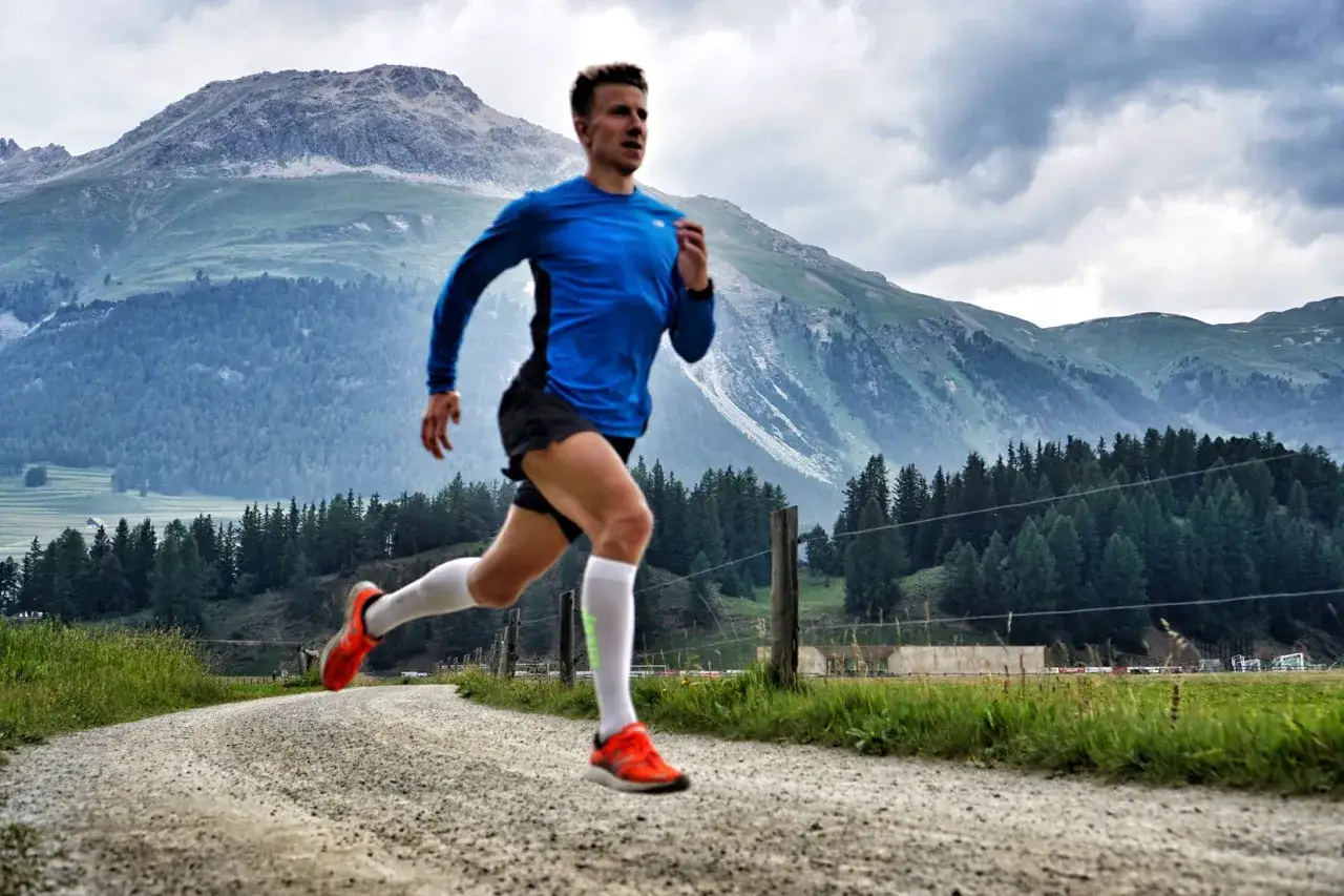 Biegacz w skarpetach kompresyjnych na leśnej ścieżce