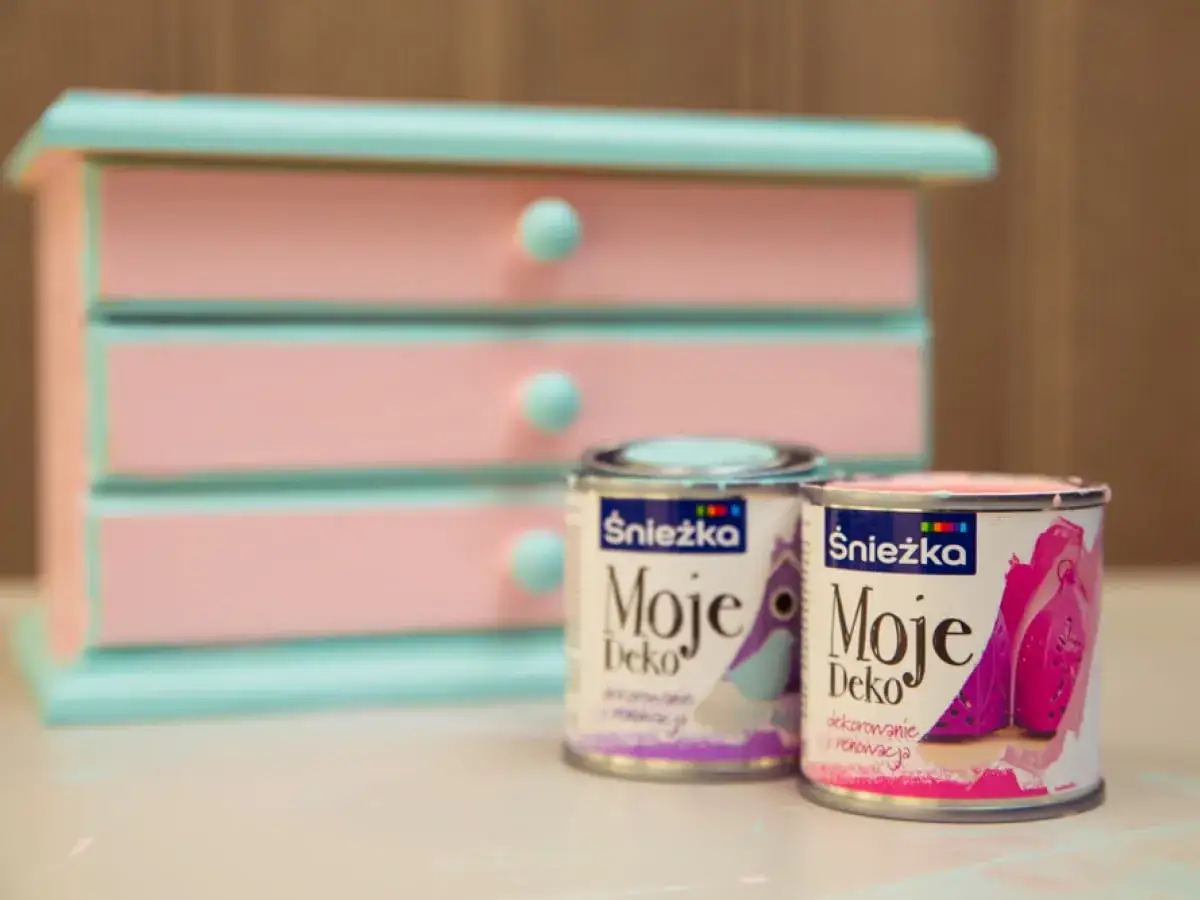 Dwie puszki farby Śnieżka Moje Deko w pastelowych kolorach, gotowe do odnowienia różowo-miętowej szkatułki.