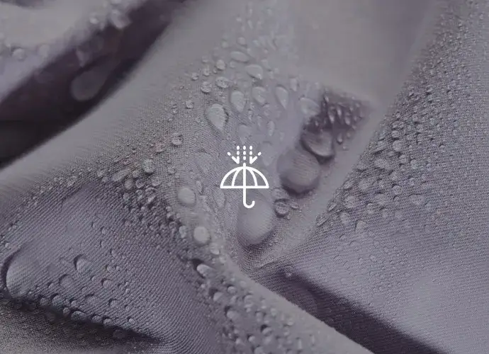 zbliżenie na materiał spodni trekkingowych z technologią DWR i kroplami wody