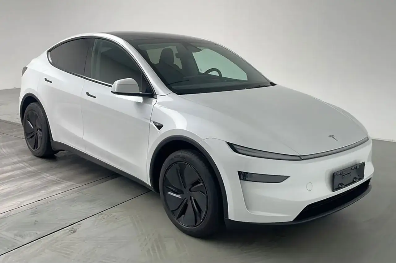 Biała Tesla Model Y, kiedy nowa tesla y, lśni w studio. Elegancka sylwetka i czarne felgi podkreślają jej nowoczesny design.