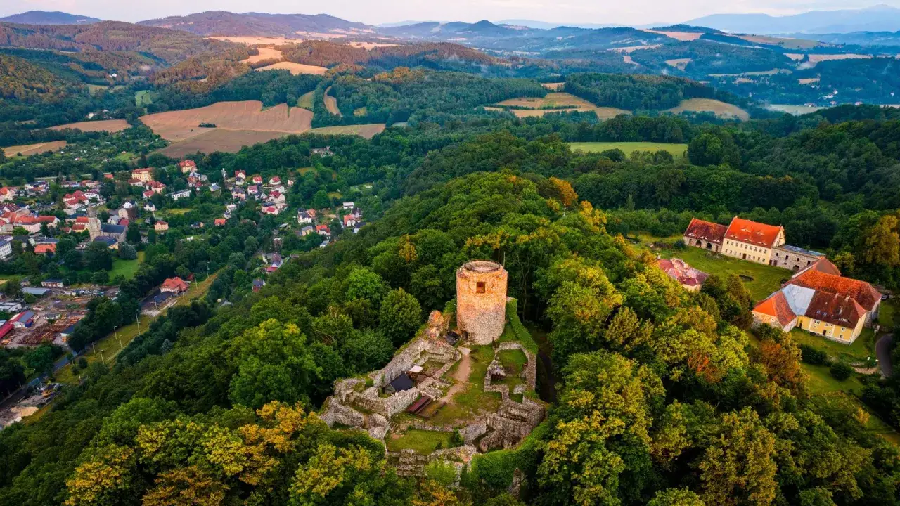 Ruiny zamku wleń na wzg&oacute;rzu, otoczone lasem. W dole miasteczko. Jak dojechać?
