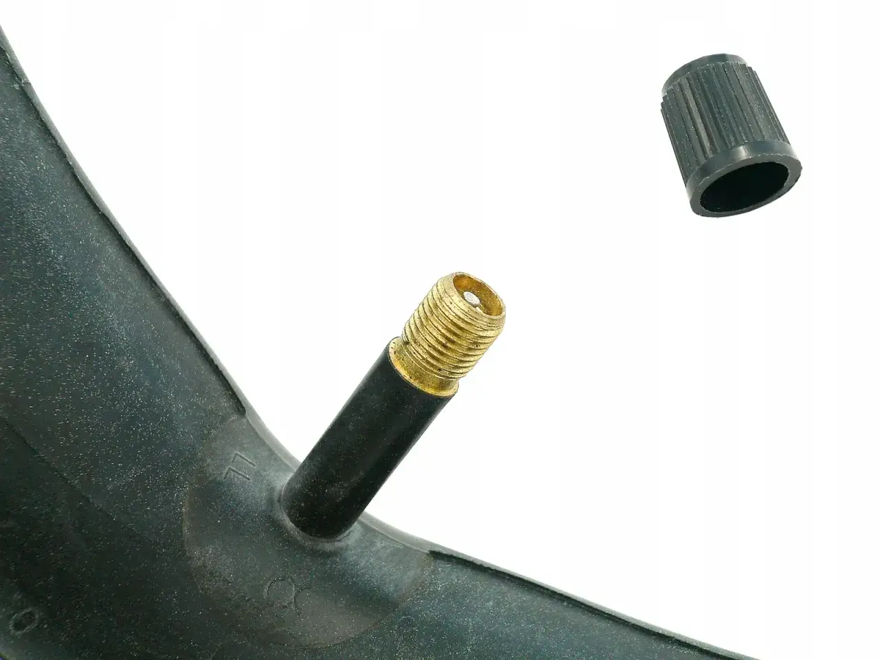 Złoty wentyl rowerowy lub samochodowy z czarną nakrętką, gotowy do pompowania.