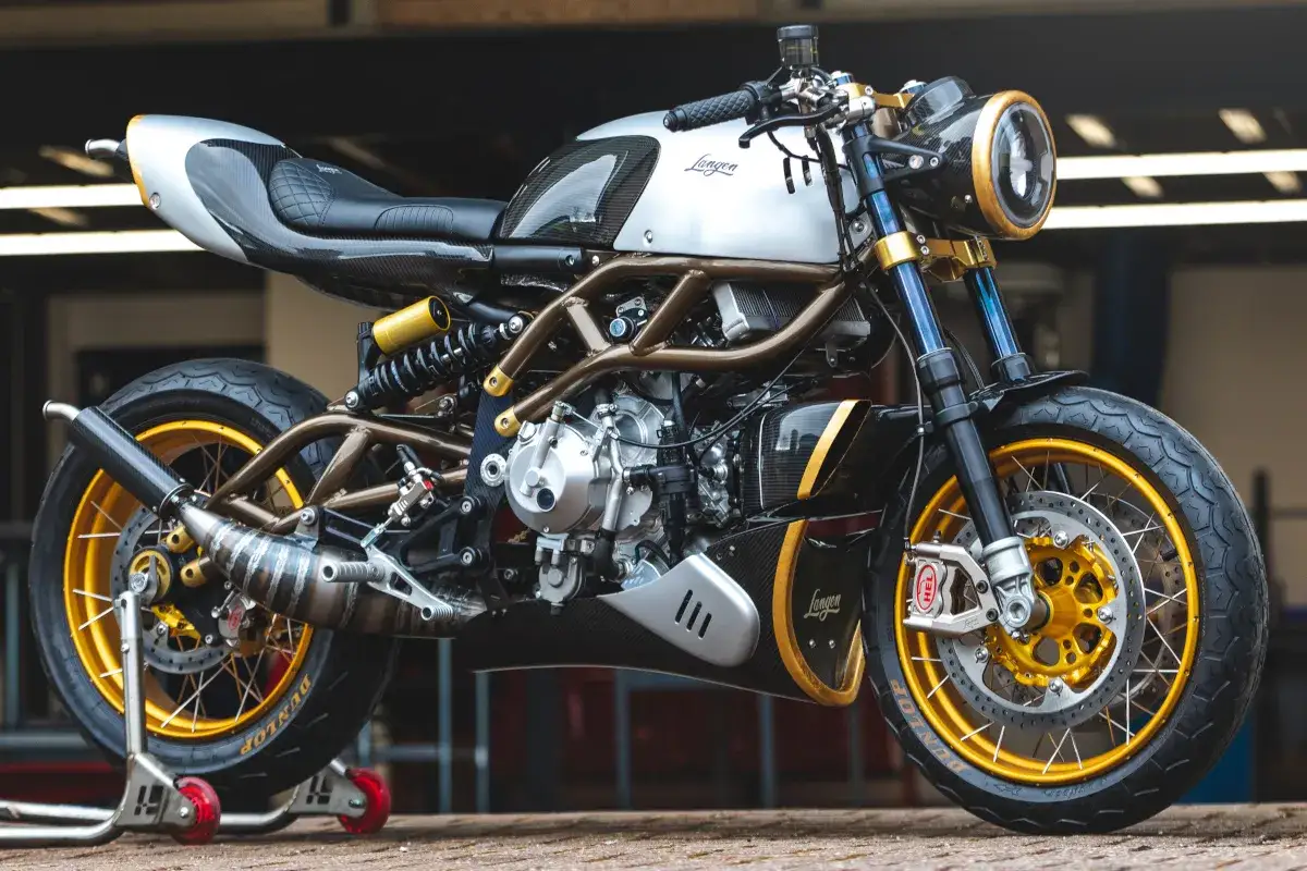 Stylowy motocykl dwusuwowy Langen z ramą w kolorze miedzi, złotymi felgami i elementami z włókna węglowego.