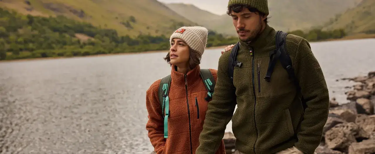 Para na tle jeziora w ciepłych polarach. Ona w rudym, on w zielonym. Idealne na wędr&oacute;wkę, bo polar co to? To komfort i ciepło.