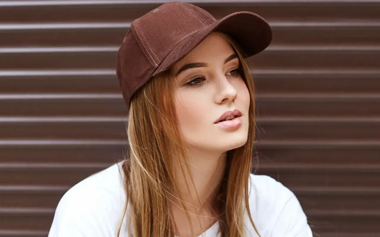 Młoda kobieta w brązowej czapce snapback, co to za styl?