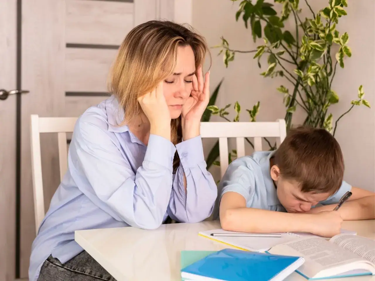 Zmęczona mama i zniechęcony syn przy biurku. Edukacja domowa na czym polega? Na nauce i frustracji.
