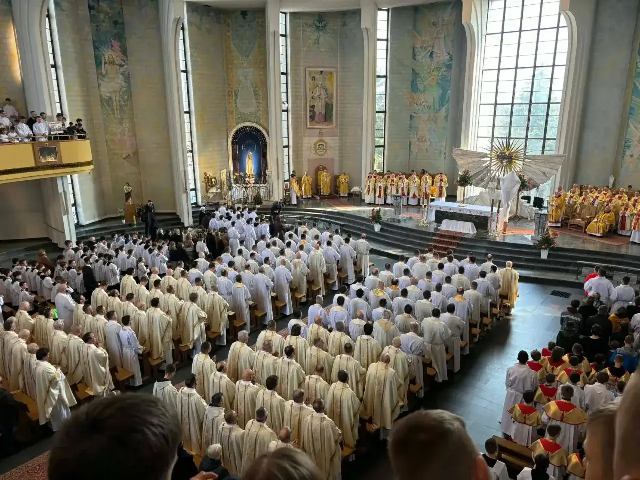 Wielki Czwartek w kościele zgromadził wielu wiernych. Widać licznych księży w szatach liturgicznych, przygotowujących się do uroczystej mszy.
