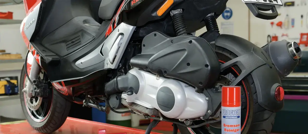 Skuter Gilera z widocznym elementem napędu. Puszka środka do czyszczenia hamulc&oacute;w sugeruje, że mogą być badane objawy zużytego wariatora w skuterze.