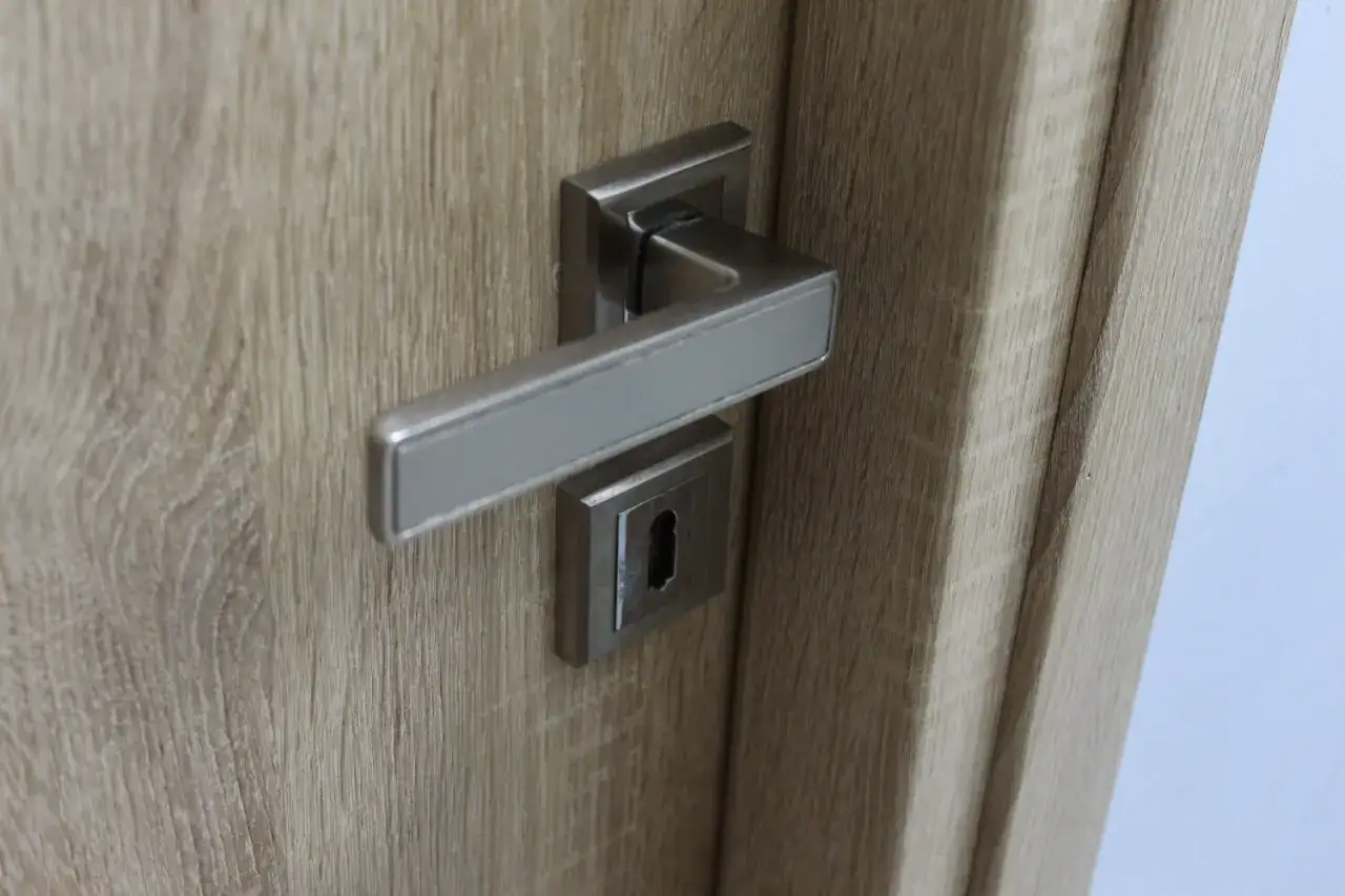 Nowy, nowoczesny zamek w drzwiach. Kto wymienia zamki w drzwiach? Fachowiec.