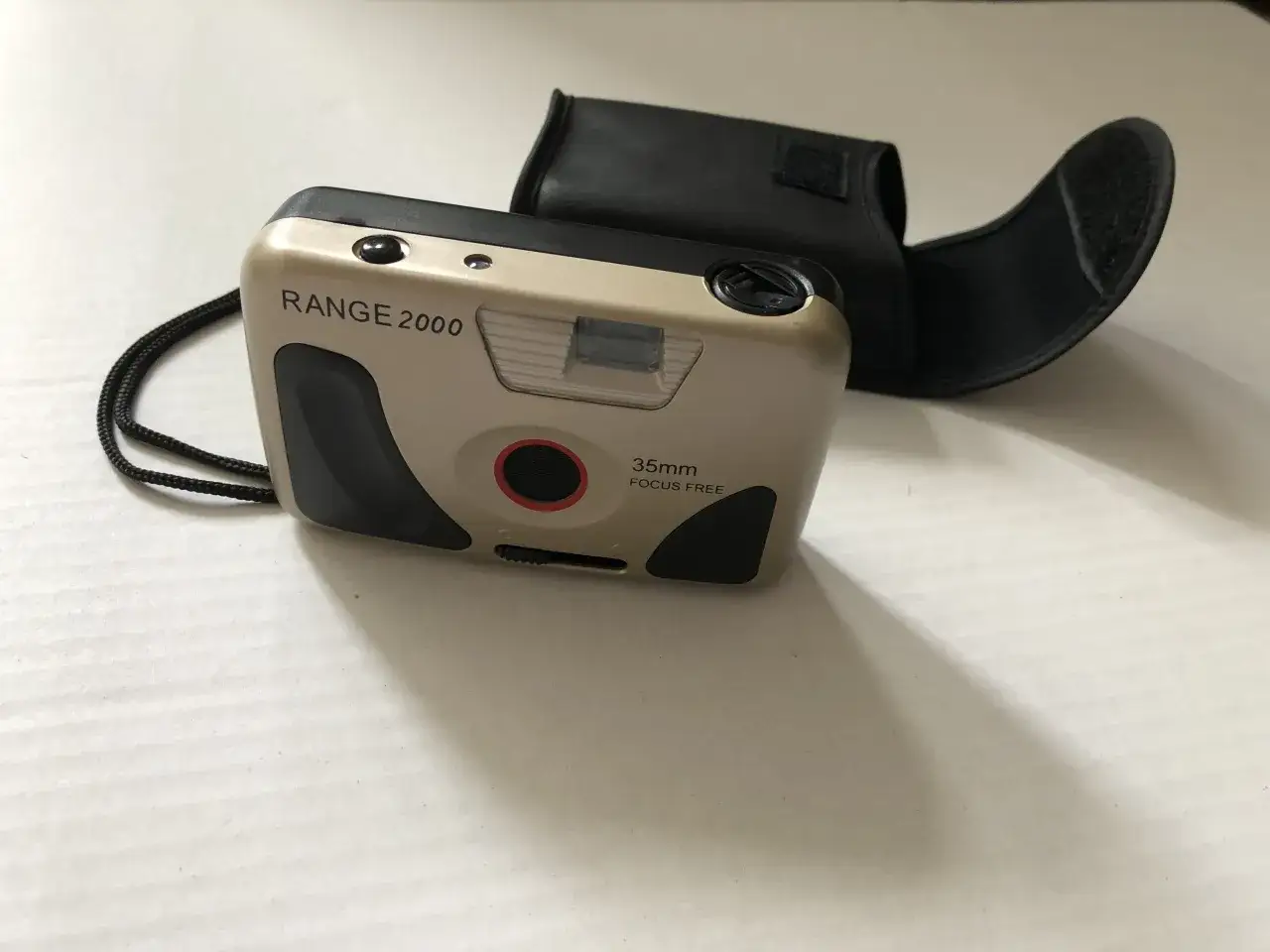 Złoty stary aparat fotograficzny na klisze Range 2000 z czarnym futerałem.