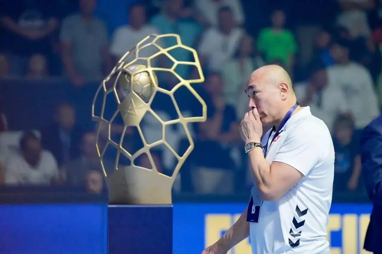 Trener zastanawia się, ile za wygranie Ligi Mistrzów, patrząc na złote trofeum.