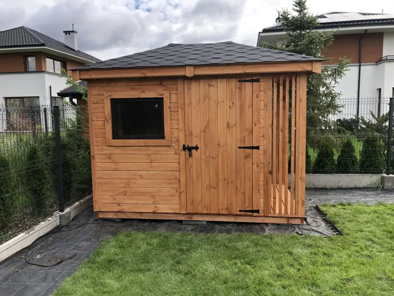 Drewniany domek narzędziowy z oknem i drzwiami. Zastanawiasz się, czy domek narzędziowy trzeba zgłaszać?