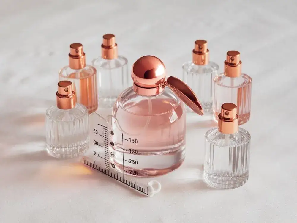 flakon perfum 100ml obok miarki krawieckiej