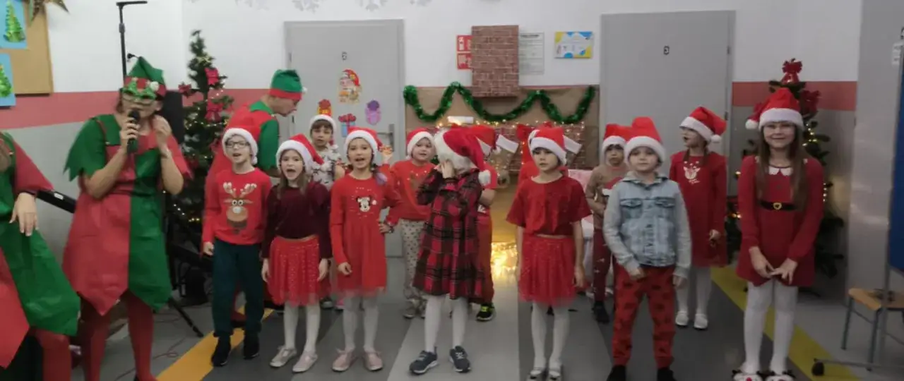 Dzieci w świątecznych strojach, z elfami na czele, śpiewają piosenki. Wspaniałe pomysły na mikołajki klasowe!