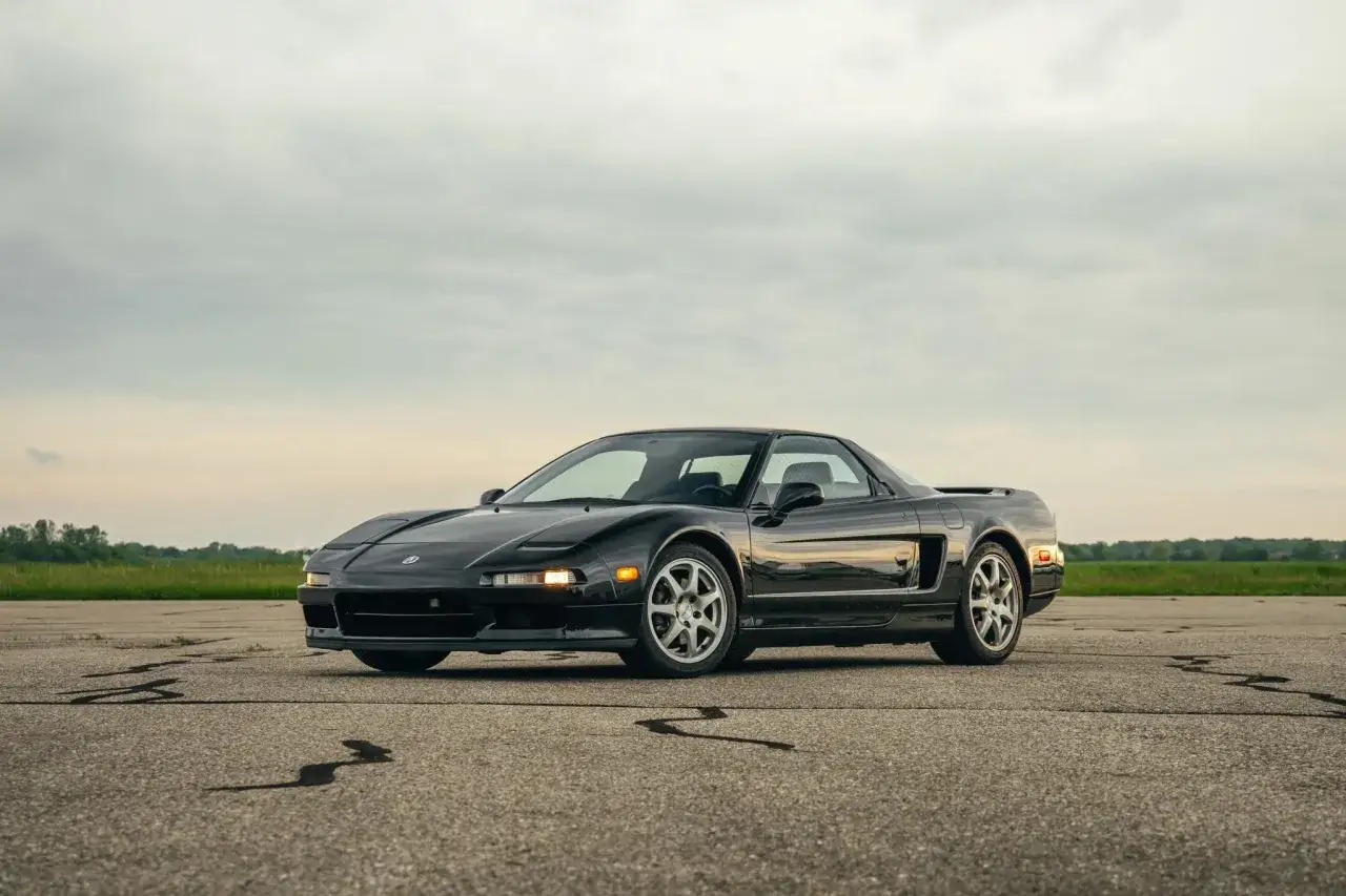 Czarny Honda NSX na pustym lotnisku, gotowy do jazdy.