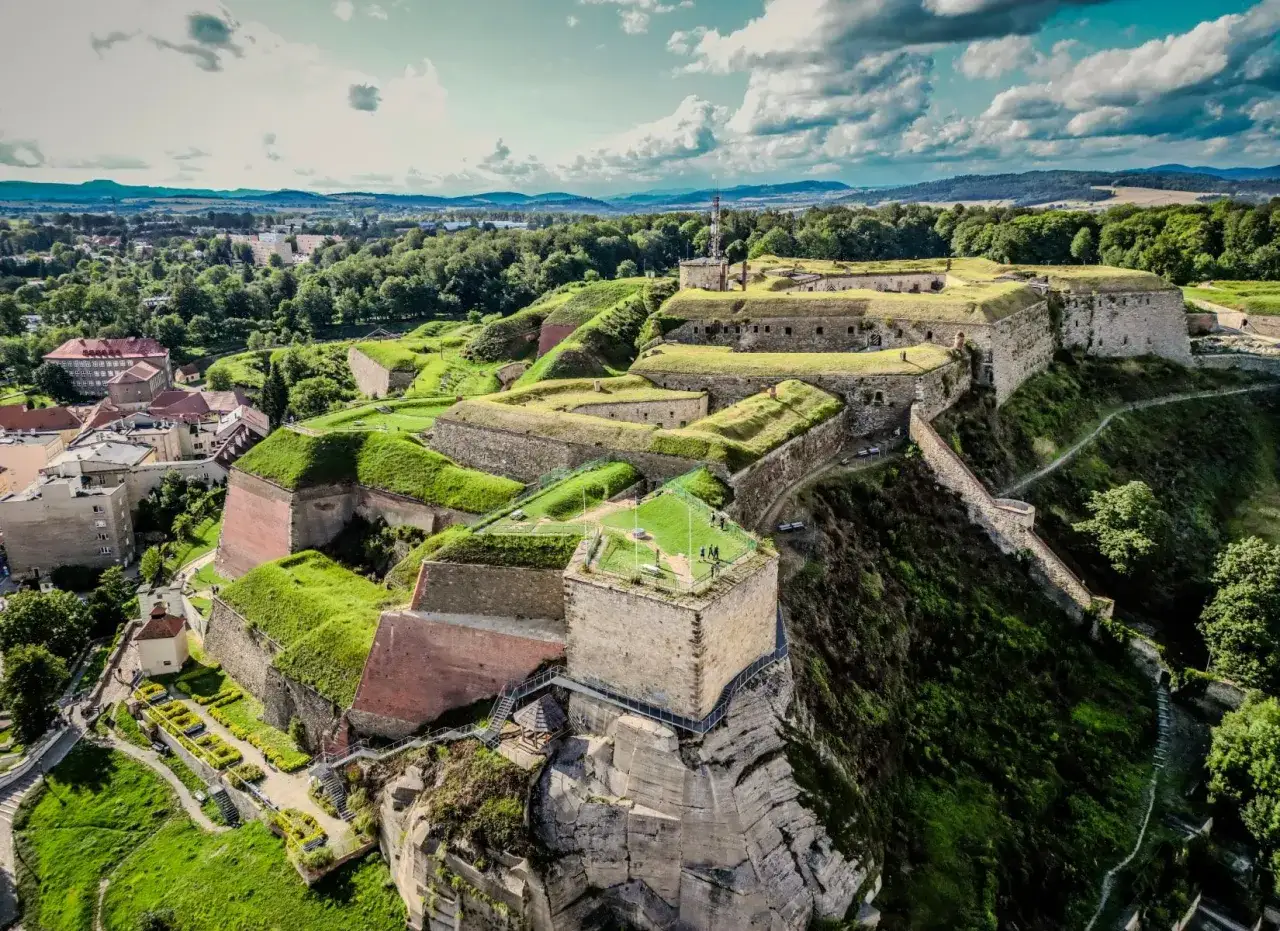 Imponująca twierdza w Dusznikach Zdroju, z zielonymi bastionami i kamiennymi murami, góruje nad miastem.
