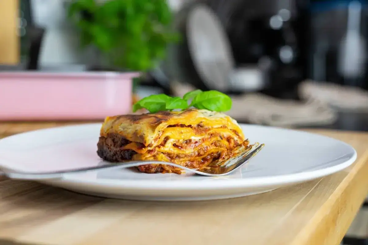 Pyszna lasagne na talerzu, gotowa do podania. Idealna do podgrzewania w piekarniku, ile stopni? Zależy od przepisu!