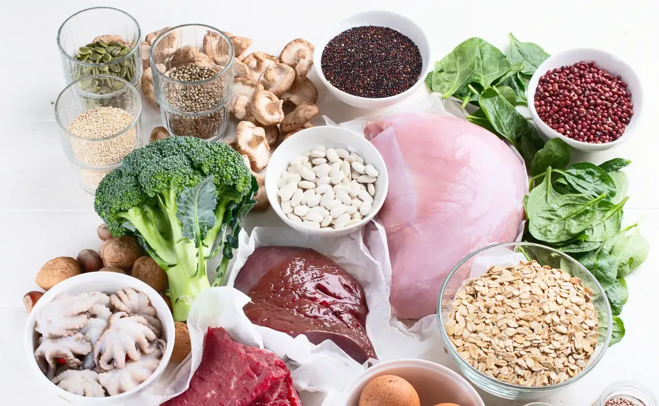 W diecie przy anemii, jakie mięso ma najwięcej łatwo przyswajalnego żelaza? Na zdjęciu widać wątróbkę, wołowinę, indyka, jajka, szpinak, fasolę, orzechy, nasiona i brokuły.