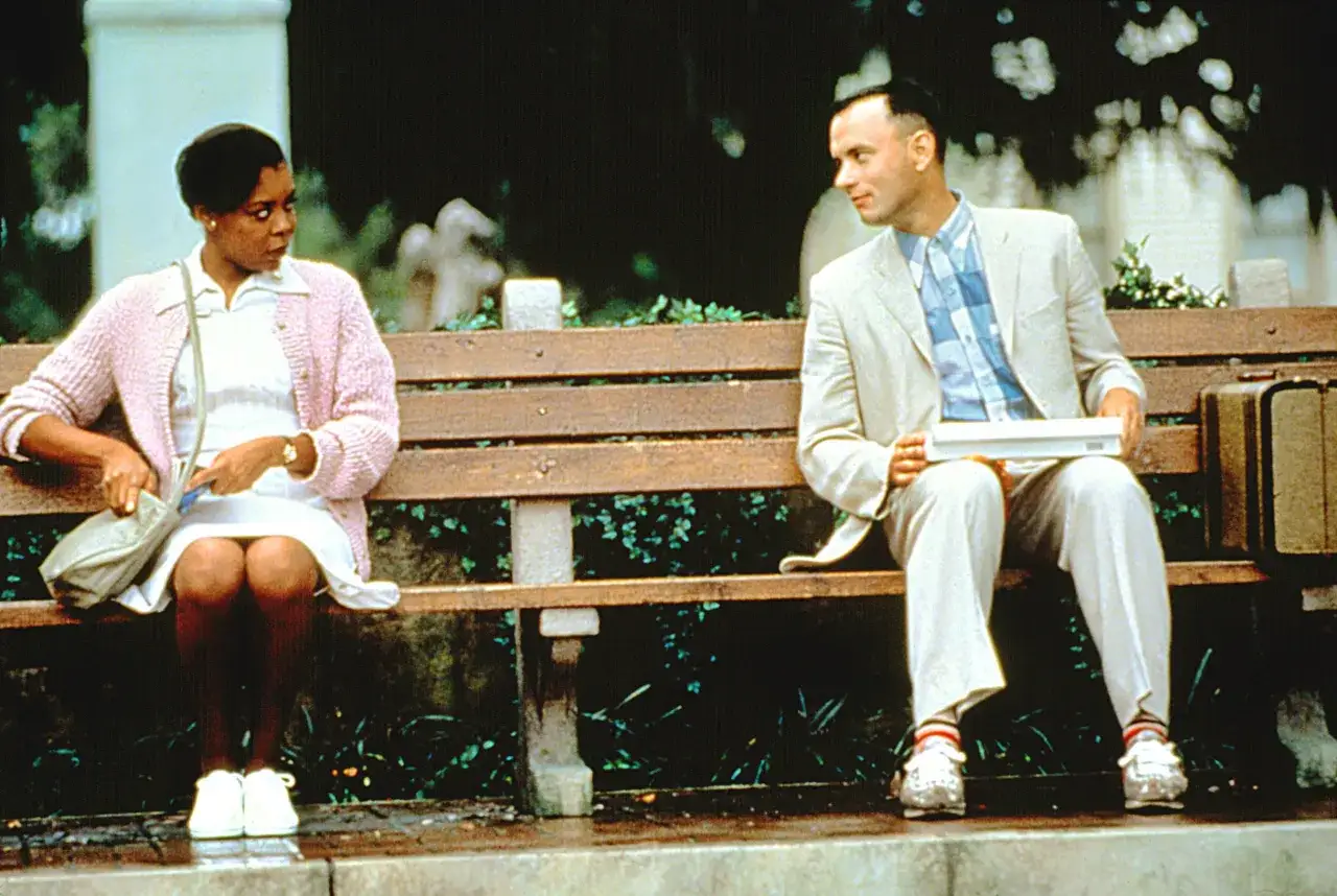 Forrest Gump obsada: Tom Hanks i Robin Wright siedzą na ławce, czekając na autobus.