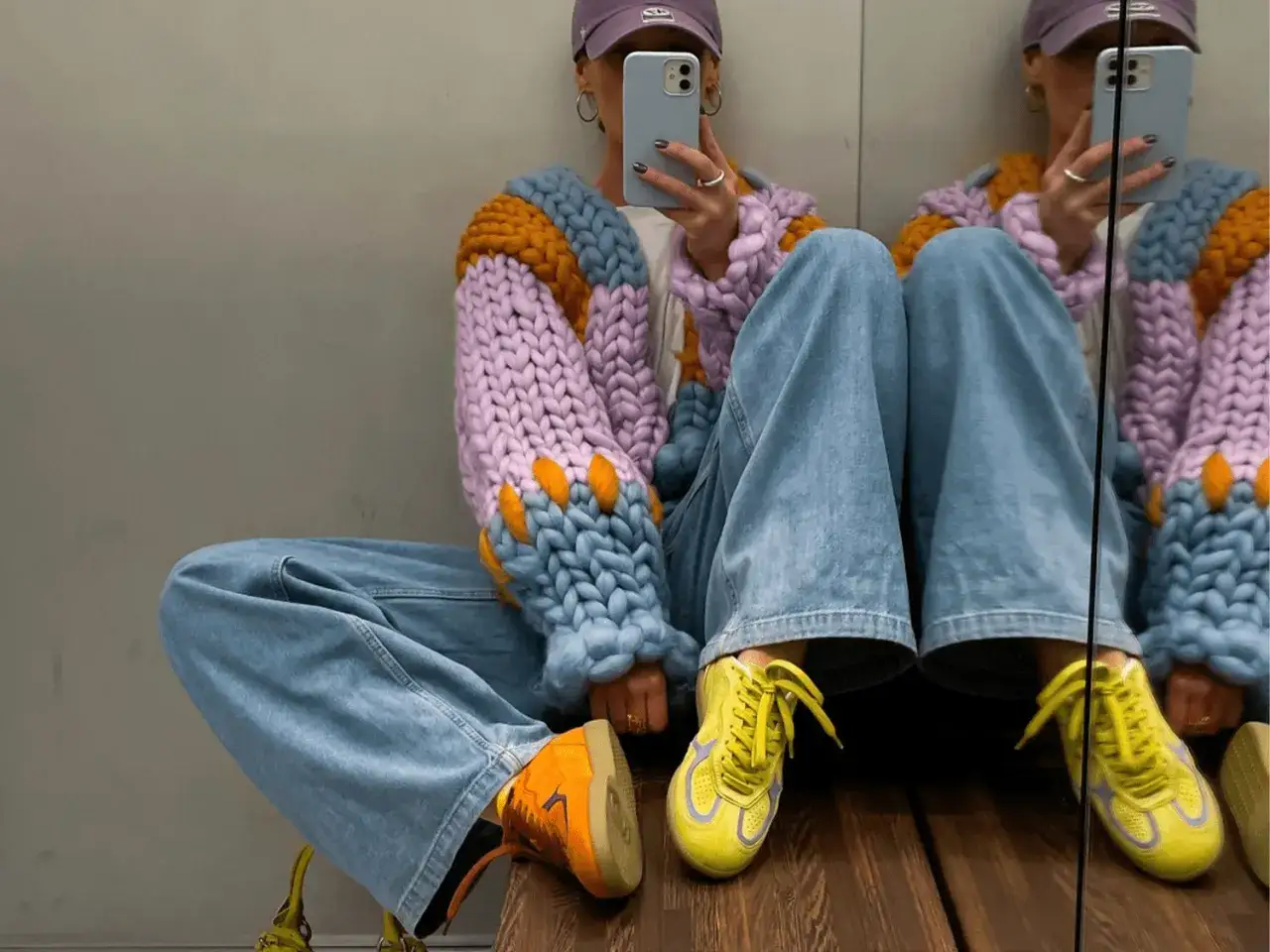 Kolorowe sneakersy co to za buty? Stylizacja z jeansami i grubym swetrem.