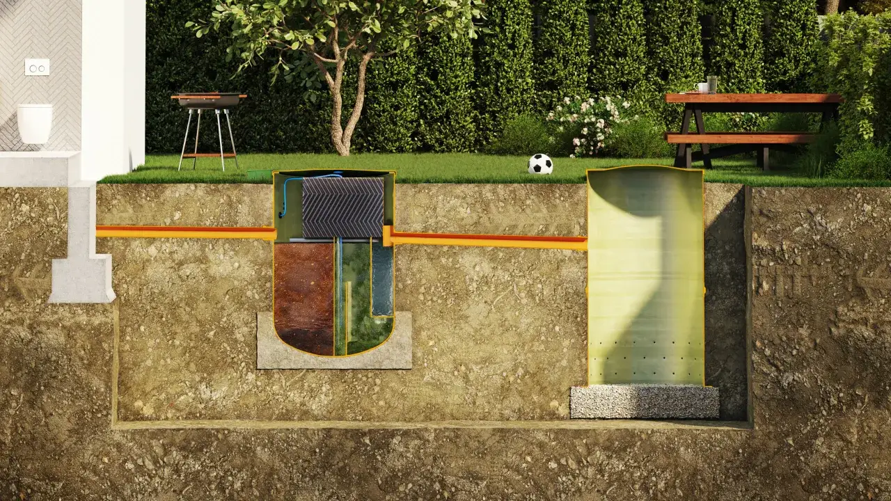 Przekrój pokazuje, jak wygląda montaż oczyszczalni przydomowej: od toalety przez zbiornik, aż do drenażu.