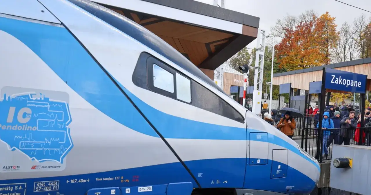 Pociąg Pendolino do Zakopanego czeka na pasażerów na peronie. Jesienne drzewa w tle.