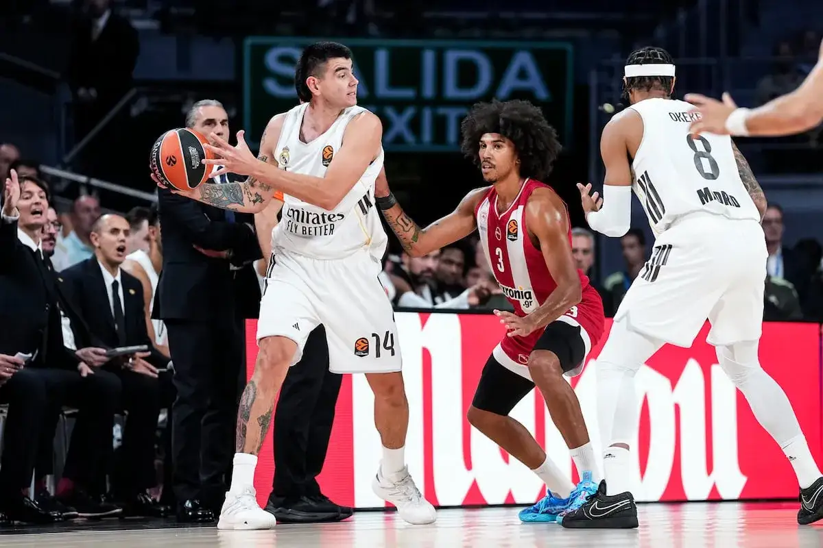 Jugador de r madrid baloncesto con el balón, defendido por un rival.