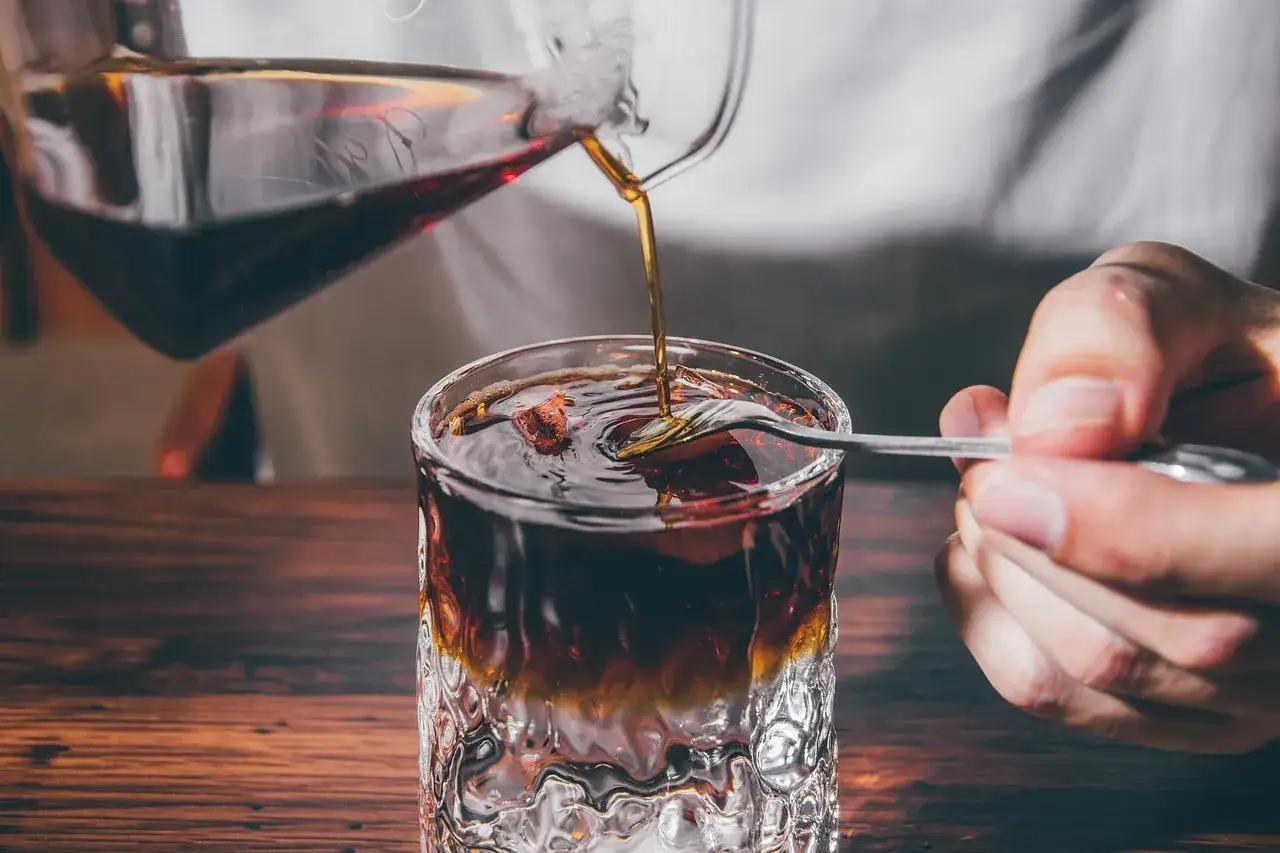 Kawa caffe coretto, z syropem wlewany do szklanki, mieszana łyżeczką.