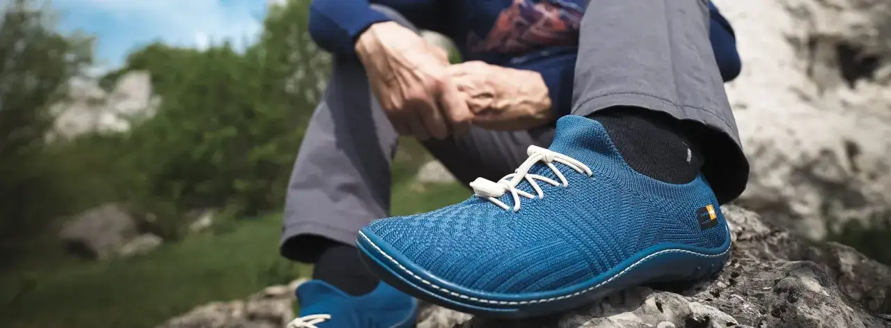 Błękitne buty do biegania naturalnego na kamienistym podłożu.