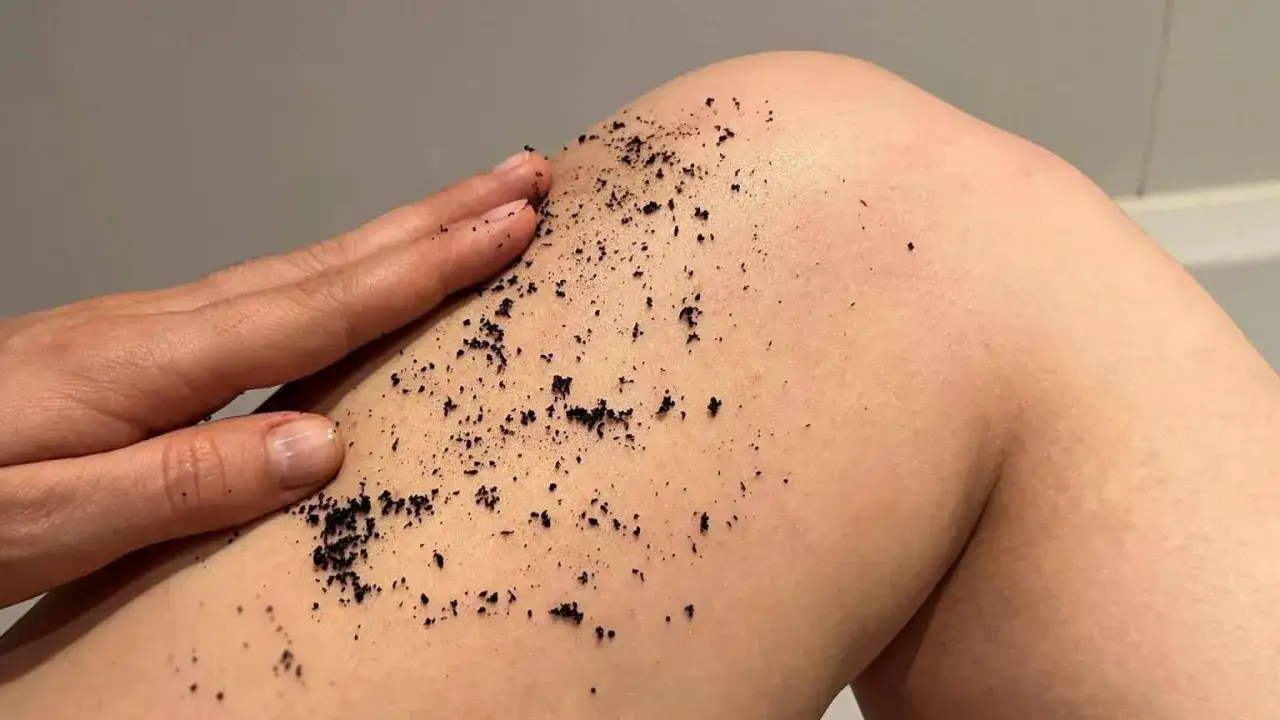 Dłoń masuje sk&oacute;rę nogi, rozprowadzając peeling. To spos&oacute;b na zapobieganie wrastające włoski i wygładzenie sk&oacute;ry.