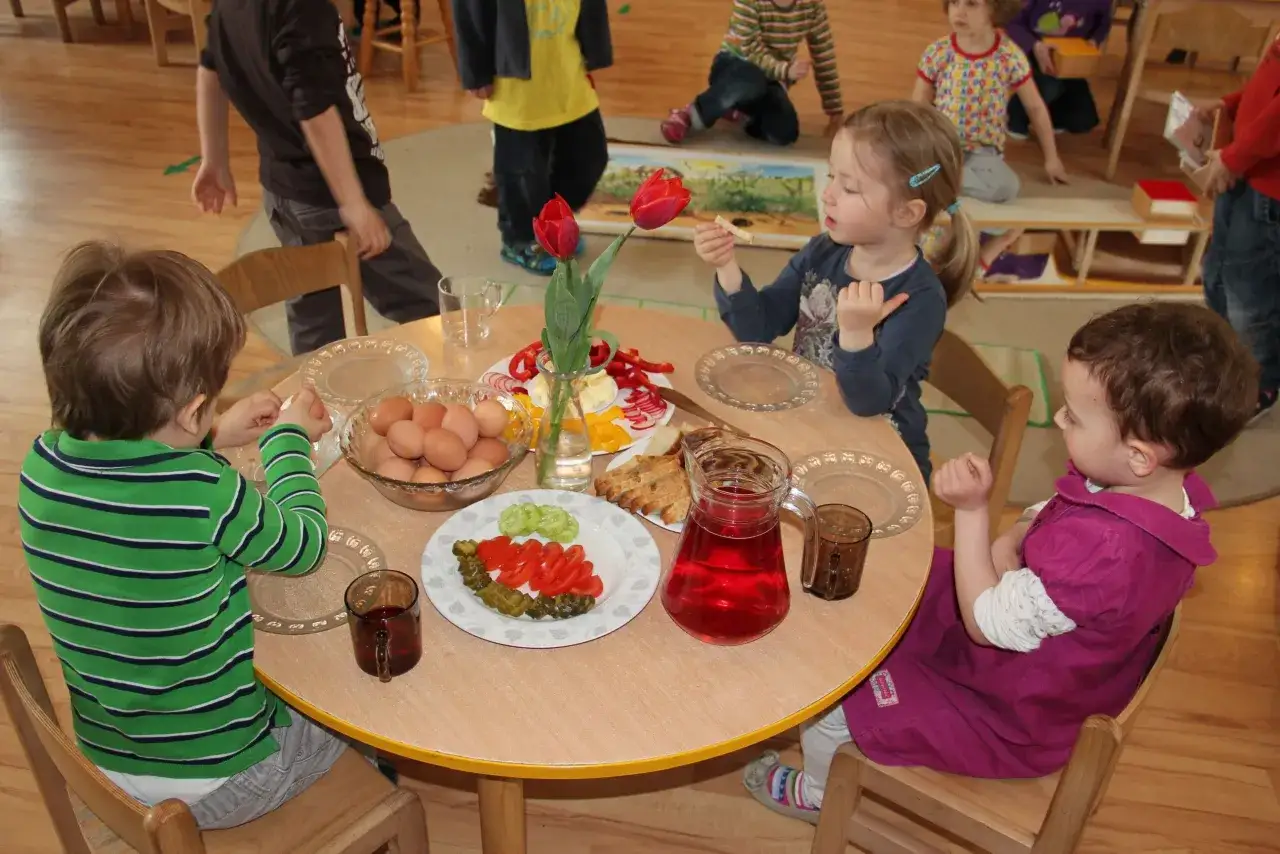 Dzieci jedzące śniadanie w żłobku przy stole
