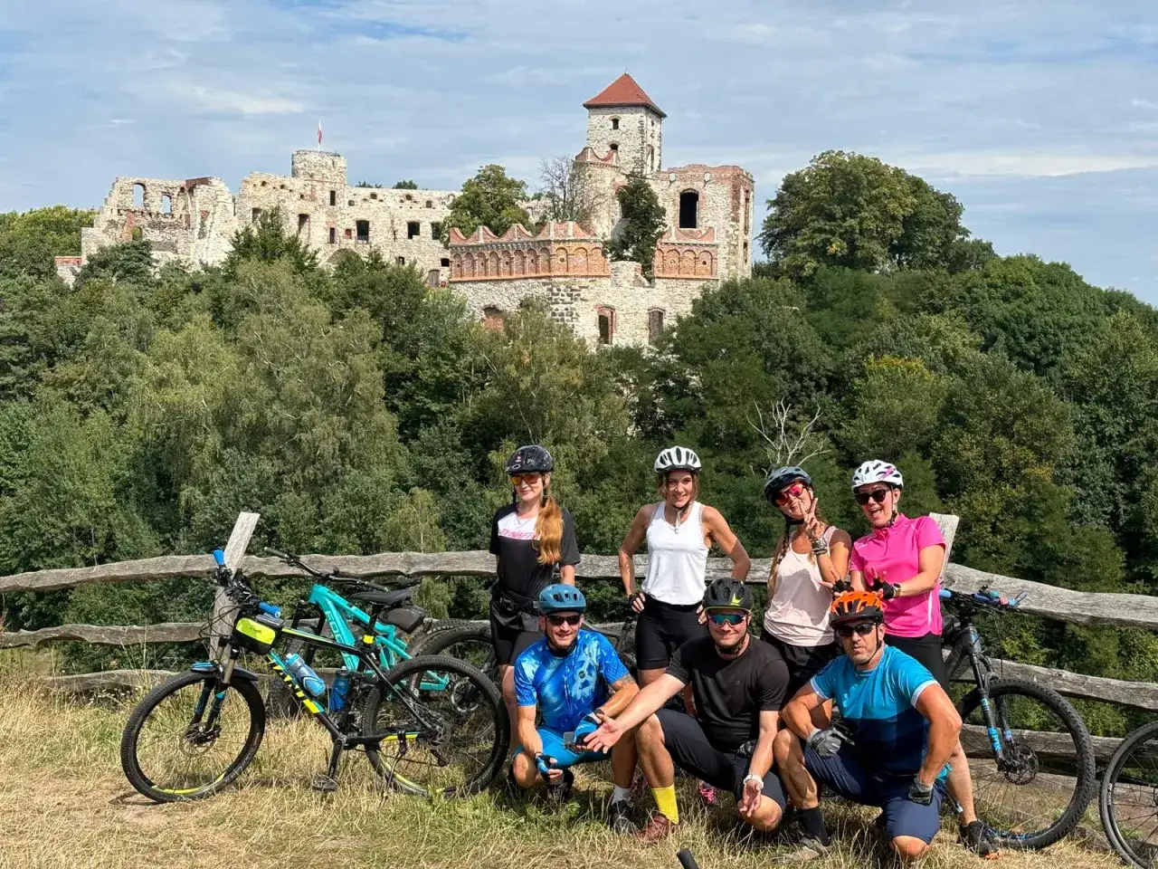 Grupa rowerzystów na tle ruin zamku, część wyprawy rowerowy szlak orlich gniazd.