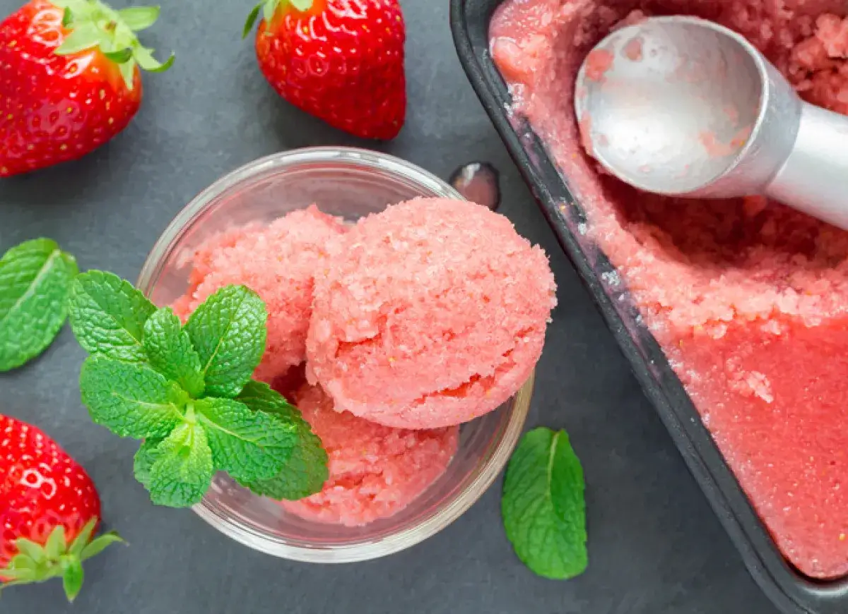 Jak zrobić sorbet truskawkowy z mrożonych truskawek? Pyszny, orzeźwiający deser z mrożonych owoców, ozdobiony listkami mięty.
