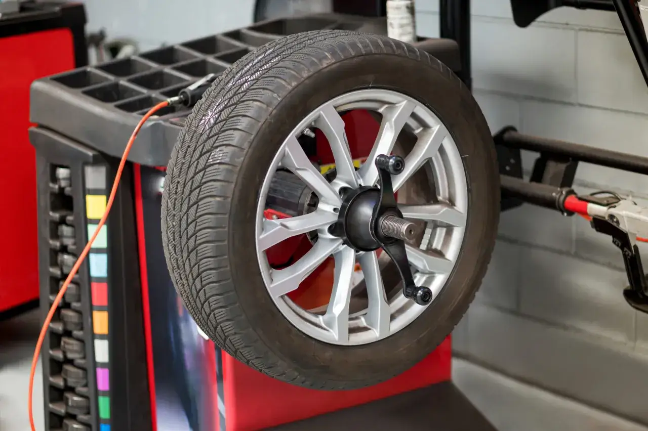 Koło samochodowe na wyważarce. Dowiedz się, ile kosztuje wymiana opon z wyważeniem.