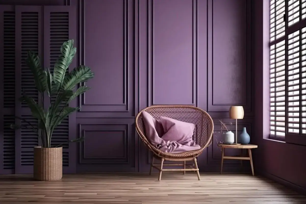 Inspiracja na to, jak pomalować salon: fioletowe ściany z boazerią, wiklinowy fotel z różową poduszką, lampka i roślina.