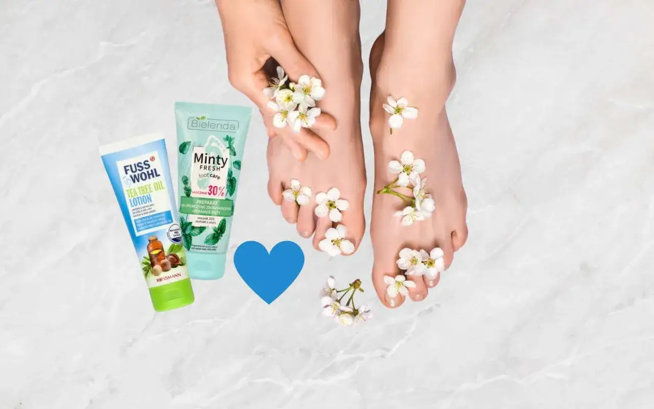 Delikatne stopy ozdobione kwiatami, obok kosmetyki na suche pięty: krem z olejkiem z drzewa herbacianego i preparat z mocznikiem 30%.