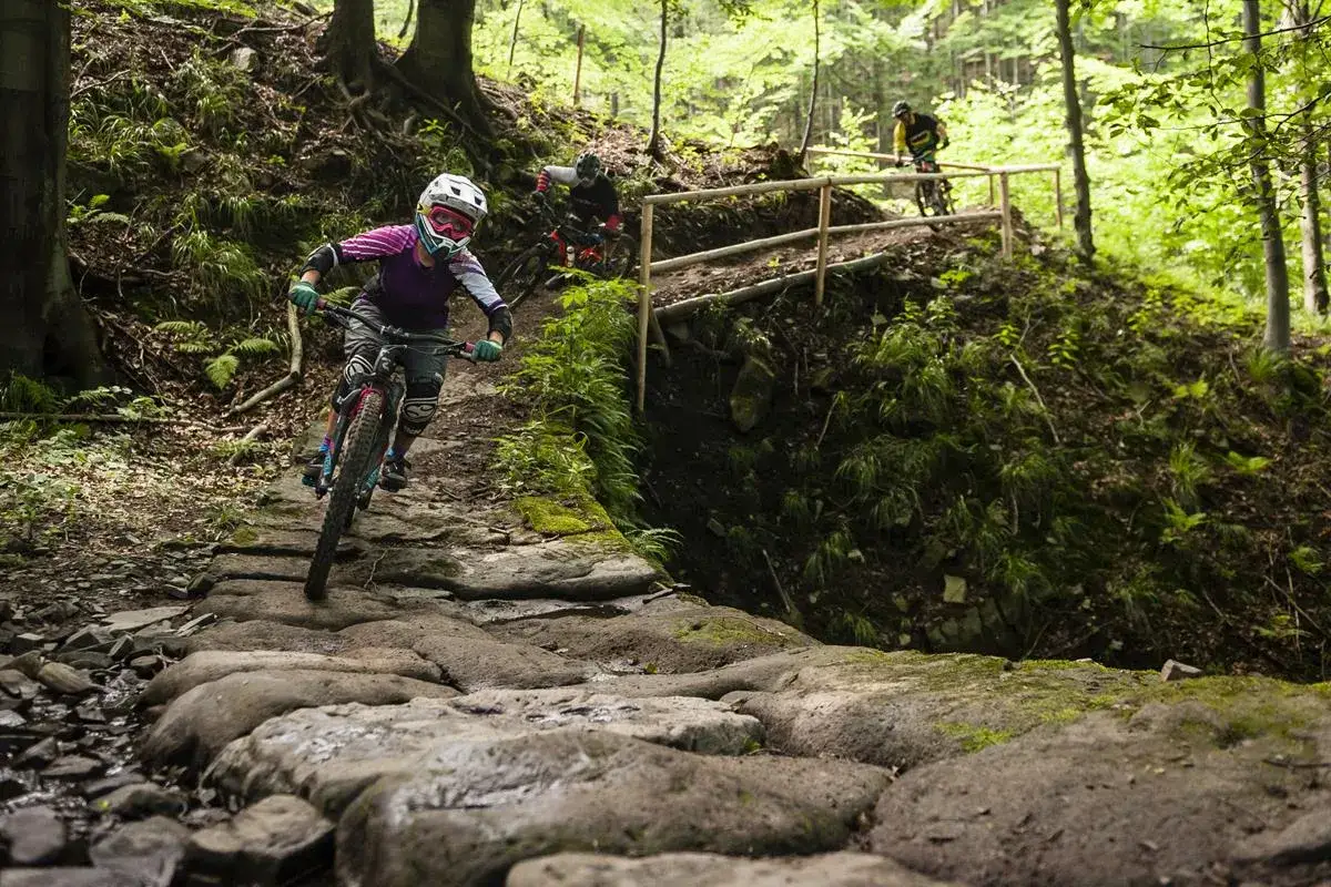 Rowerzyści pokonują kamienisty zjazd na jednej z malowniczych tras rowerowych w Bielsku.