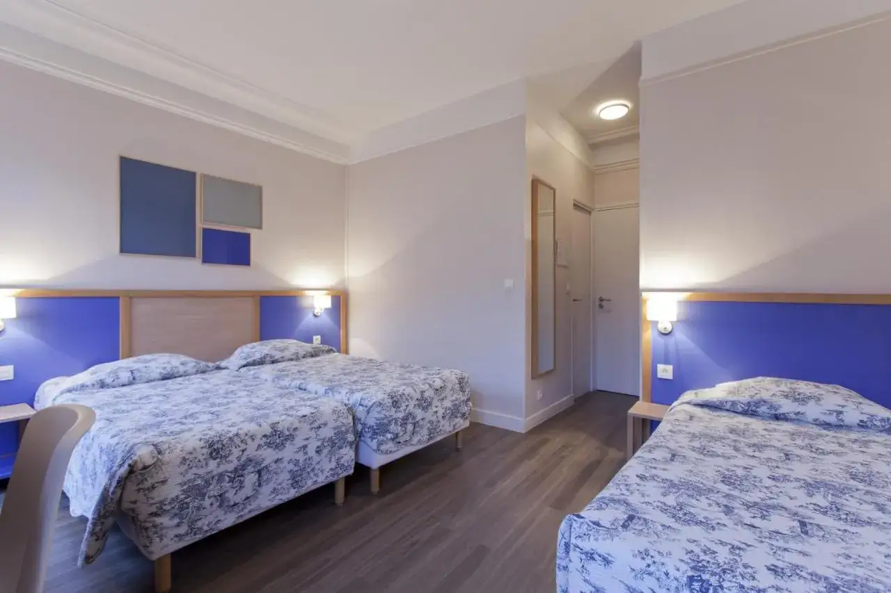 Pokój hotelowy z trzema łóżkami, idealny, gdy zastanawiasz się, gdzie spać w Paryżu.