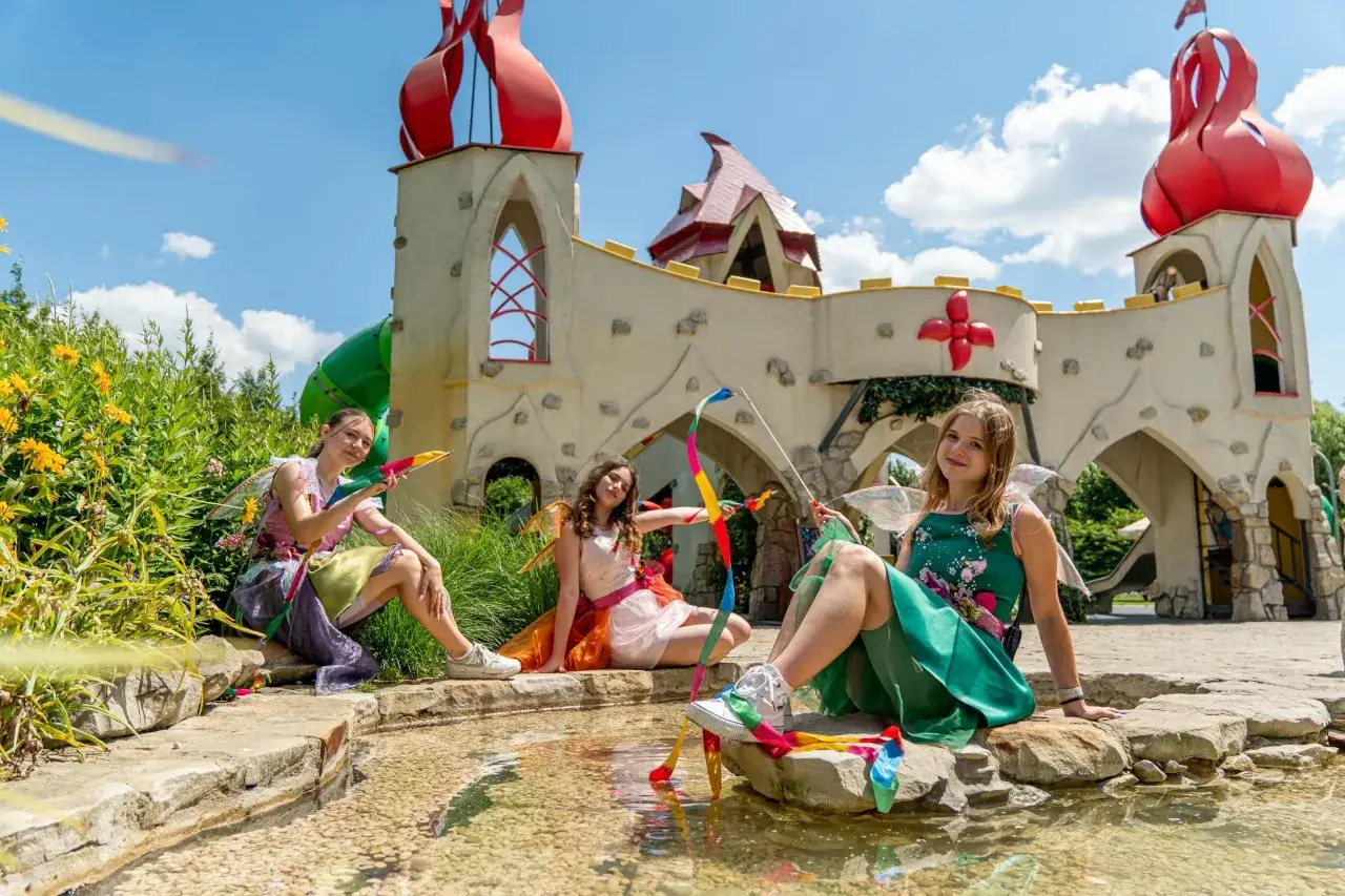 rodzina z dziećmi bawiąca się w parku rozrywki lub na ścieżce edukacyjnej