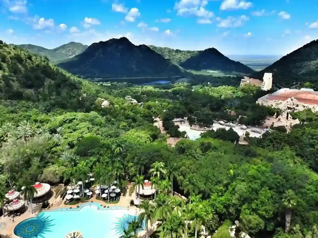 Malowniczy krajobraz z g&oacute;rami w tle, bujną zielenią i basenem w Sun City, RPA.