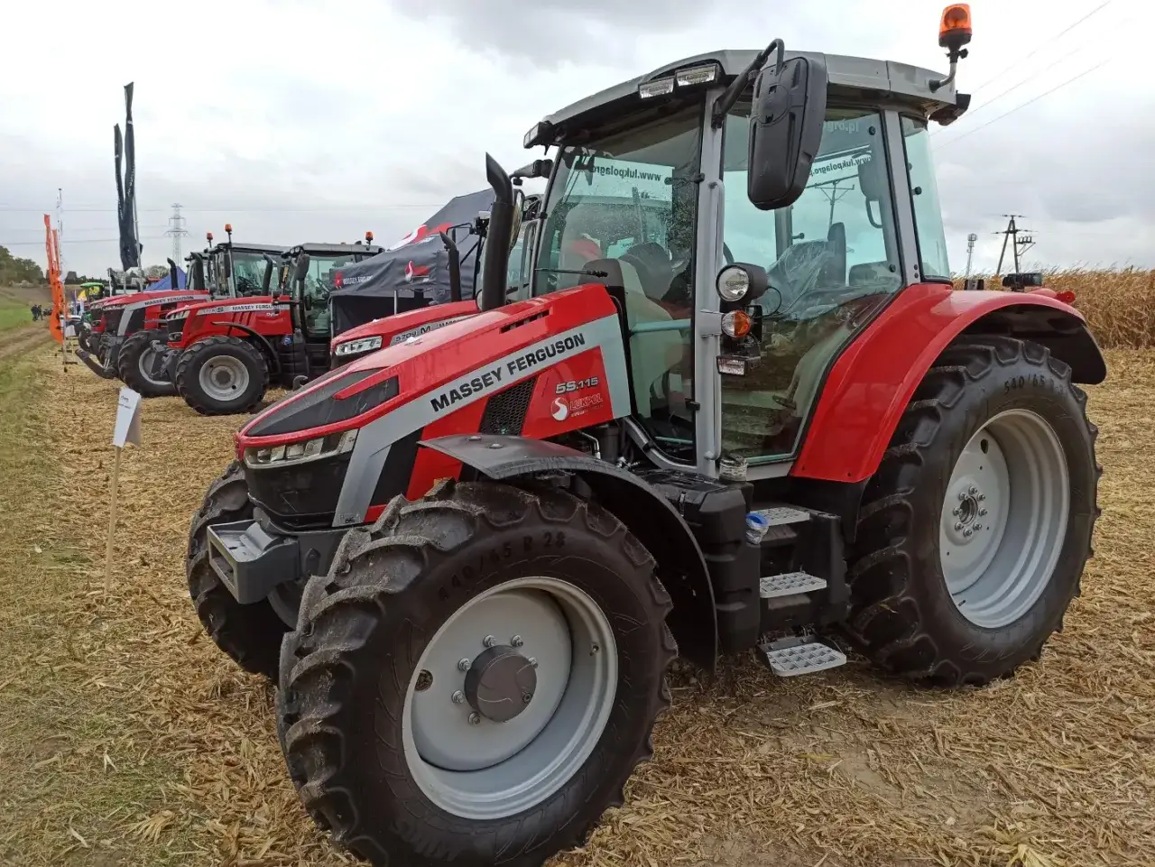 Czerwone ciągniki Massey Ferguson na polu. Zastanawiasz się, ile kosztuje ciągnik rolniczy? Oto modele, które mogą Cię zainteresować.