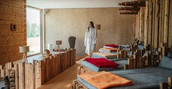 Alpine Spa-Anwendung mit Kr&auml;uterstempeln und Naturprodukten