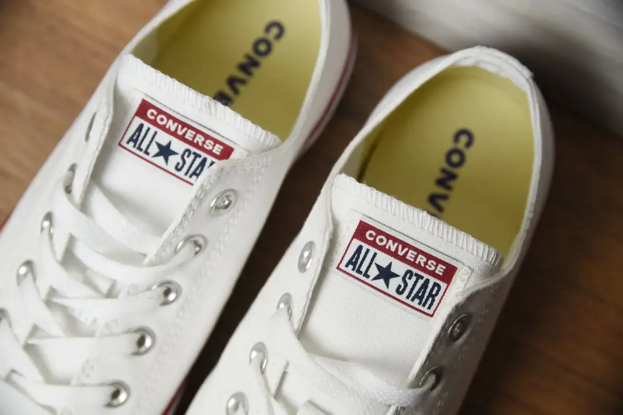 Białe, sznurowane trampki Converse All Star. Zwróć uwagę na detale, by odróżnić oryginalne converse od podróbek.