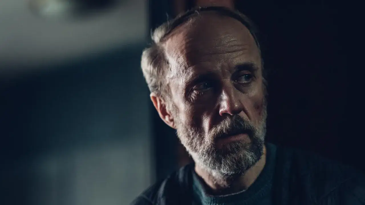 Portret mężczyzny z siwą brodą i zmarszczkami. Zastanawia się, w jakich filmach grał Łukasz Simlat.