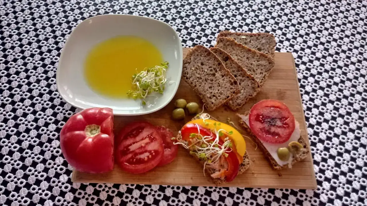 Zdrowa przekąska: ciemne pieczywo, pomidory, papryka, oliwki i kiełki. Do tego miseczka z płynnym złotem &ndash; olej lniany właściwości zdrowotne ma nieocenione.