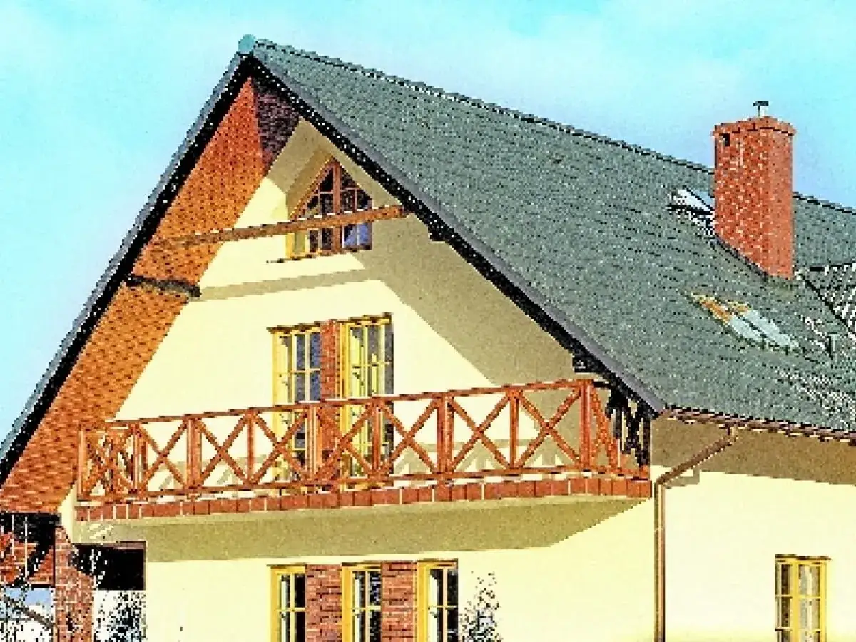 Wykończenie ściany szczytowej domu z drewnianą balustradą balkonu i ceglanym kominem.