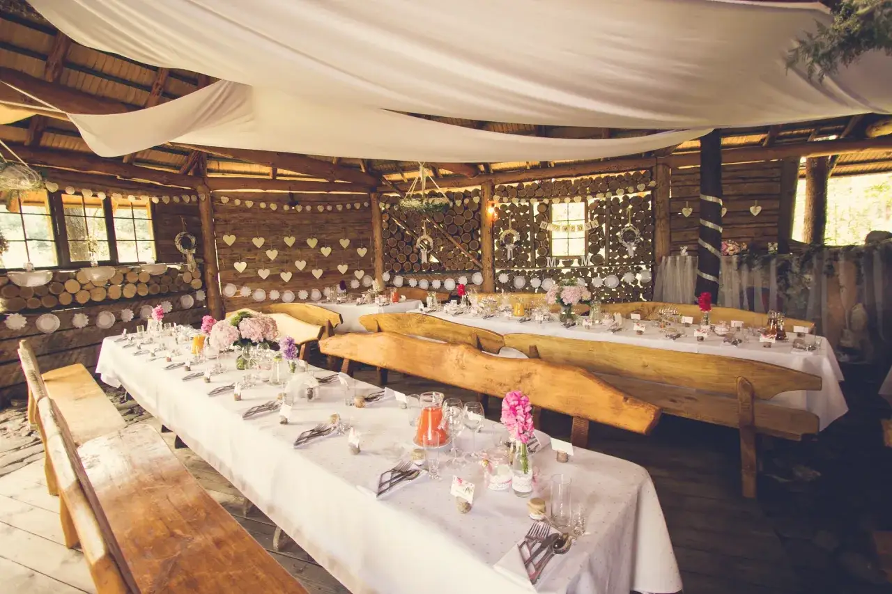 Uroczyste stoły na rancho pod bocianem, udekorowane kwiatami i serduszkami, czekają na gości.