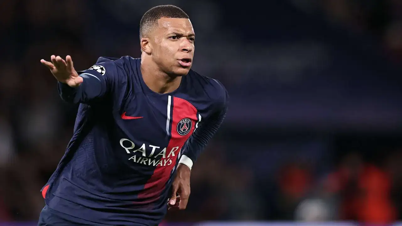 Kylian Mbappé w ciemnym stroju PSG, skupiony na grze. Jego sylwetka i dynamika sugerują, że jego waga jest idealnie dopasowana do potrzeb piłkarza.